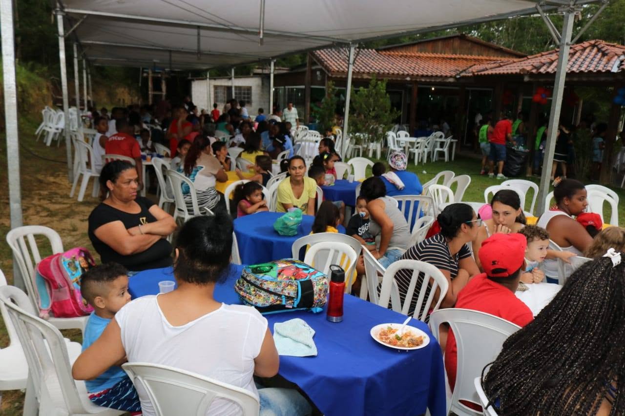 Crianças recebendo sacolinhas de Natal do Sorriso em Ação.