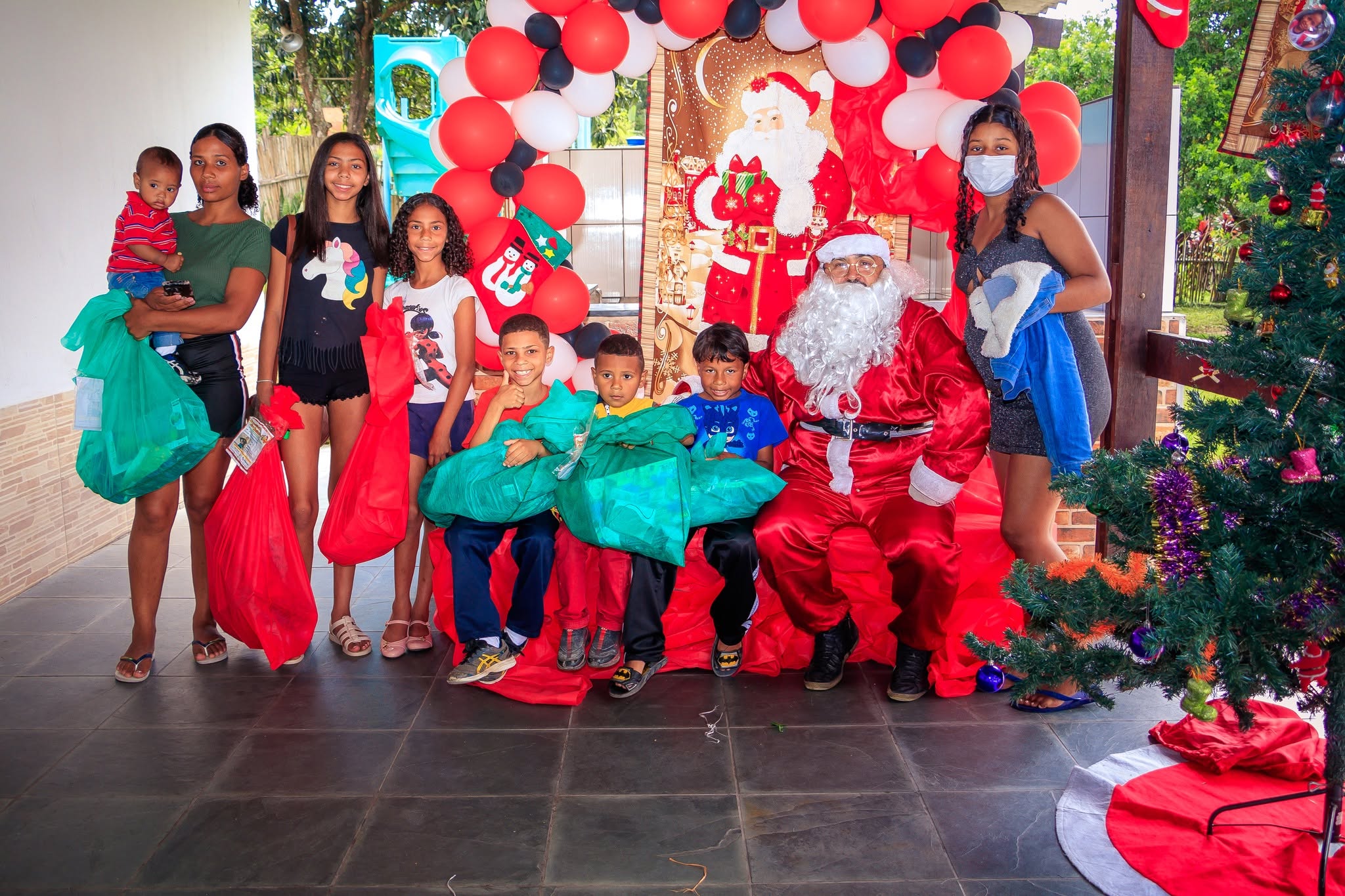 Crianças com o Papai Noel durante a Sacolinha de Natal do Sorriso em Ação.