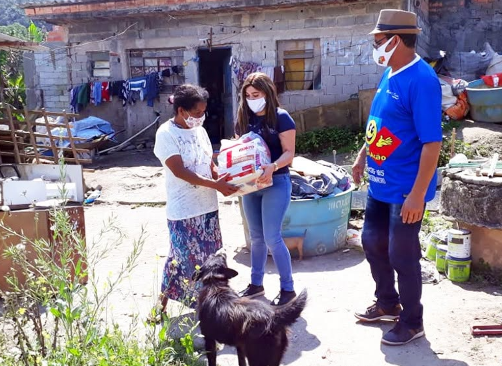Voluntária do Sorriso em Ação entregando doação de alimentos para família de Parelheiros.