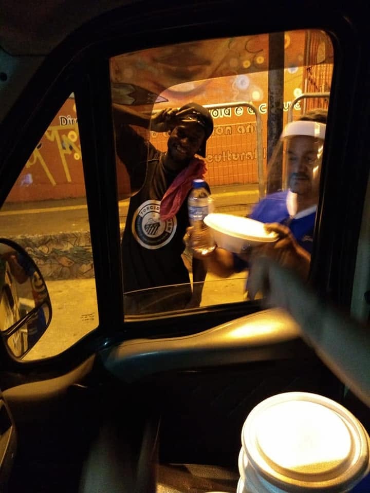 Voluntários entregando refeições e agasalhos para moradores de rua em Parelheiros.