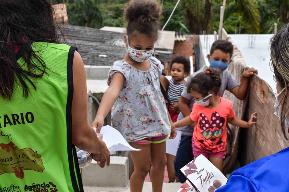 Crianças atendidas pelo Sorriso em Ação recebendo doações dos voluntários em Parelheiros.